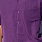 Close-up of purple 100% polyester fabric showing the solid texture and button detail