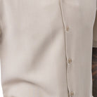 Close-up of beige men's walking suit shirt showing the detailed linen-look texture 