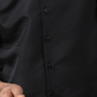 Close-up of the black tone-on-tone horizontal stripe texture on the refined polyester walking suit.