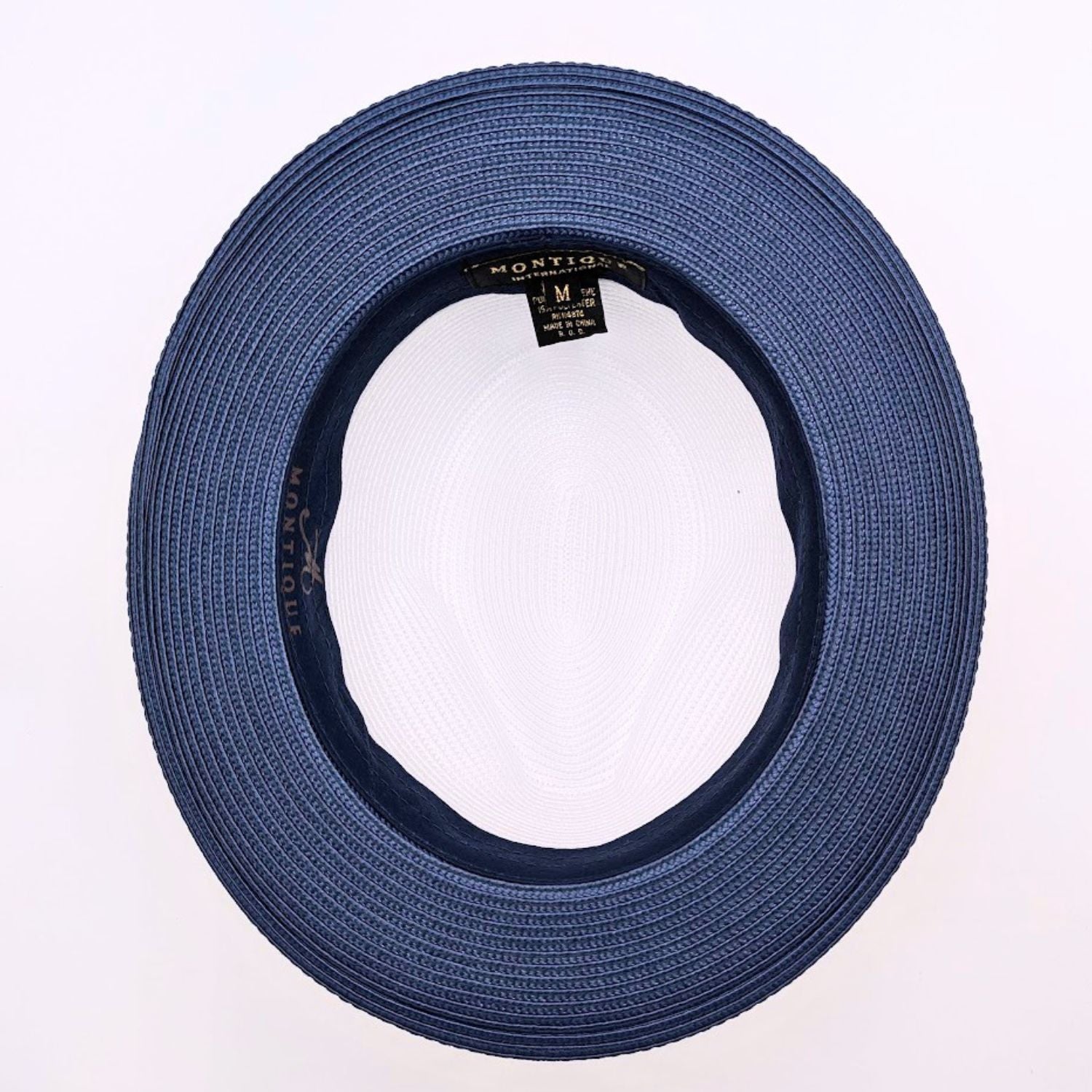 Navy and white Montique fedora hat interior view with navy woven brim, black sweatband, white crown, and branded label