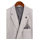 Close-up detail of light grey textured weave blazer fabric and interior lining