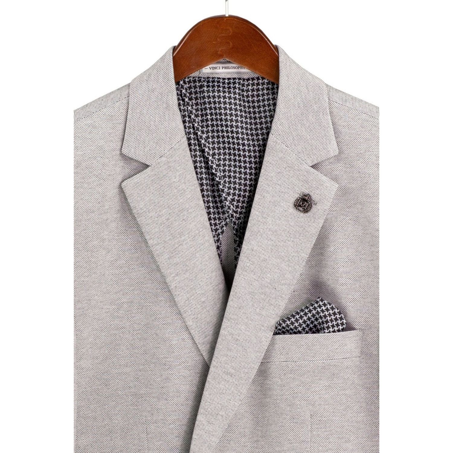 Close-up detail of light grey textured weave blazer fabric and interior lining