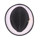 Black and white Montique fedora hat top view showing black woven crown, white brim underside, black brim edge, and side feather detail