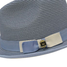 close up of Montique Carolina straw fedora hat with bow, ribbon band, and logo pin