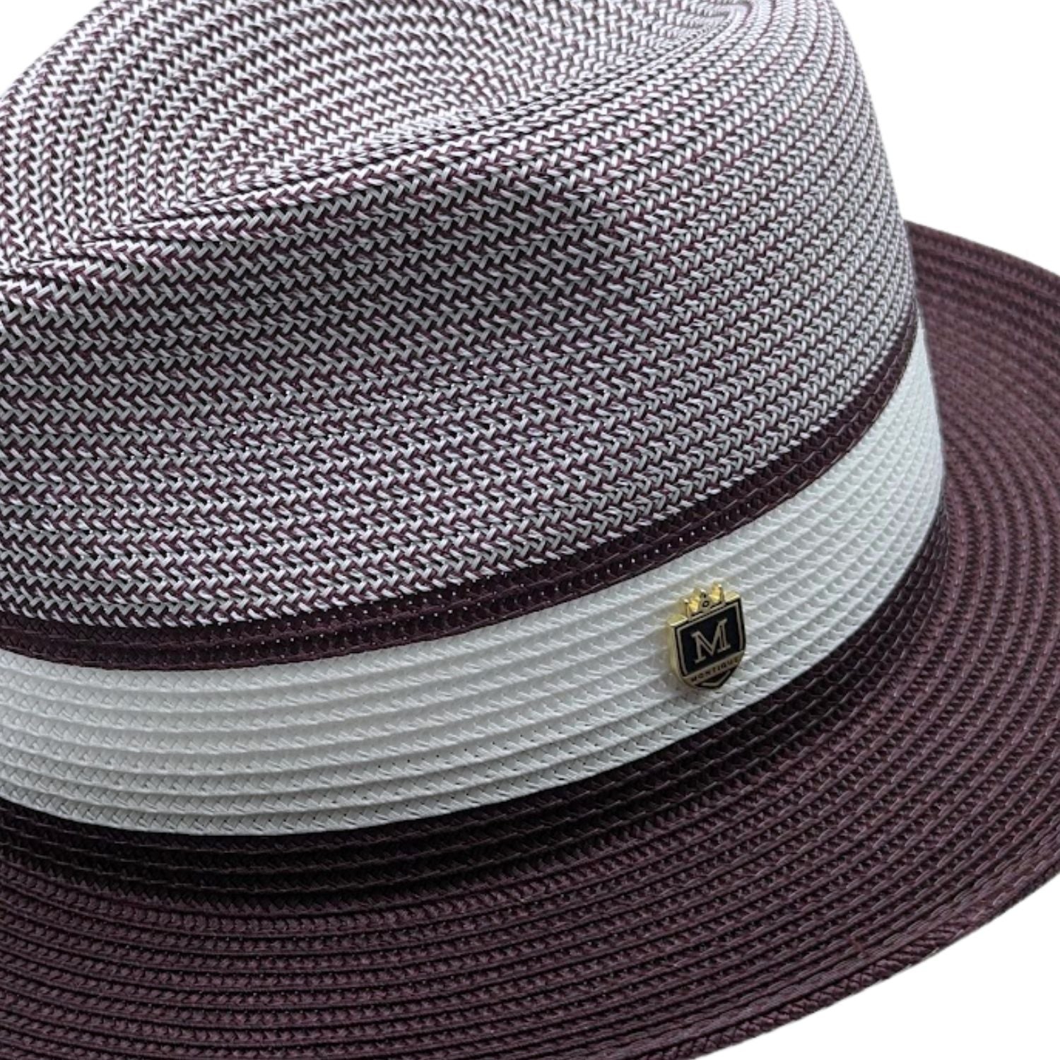 Wine and white Montique fedora hat close-up with woven crown, white band, wine brim, and logo pin