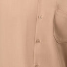 Close-up of beige solid walking suit shirt showing the open collar and clean button-front design.