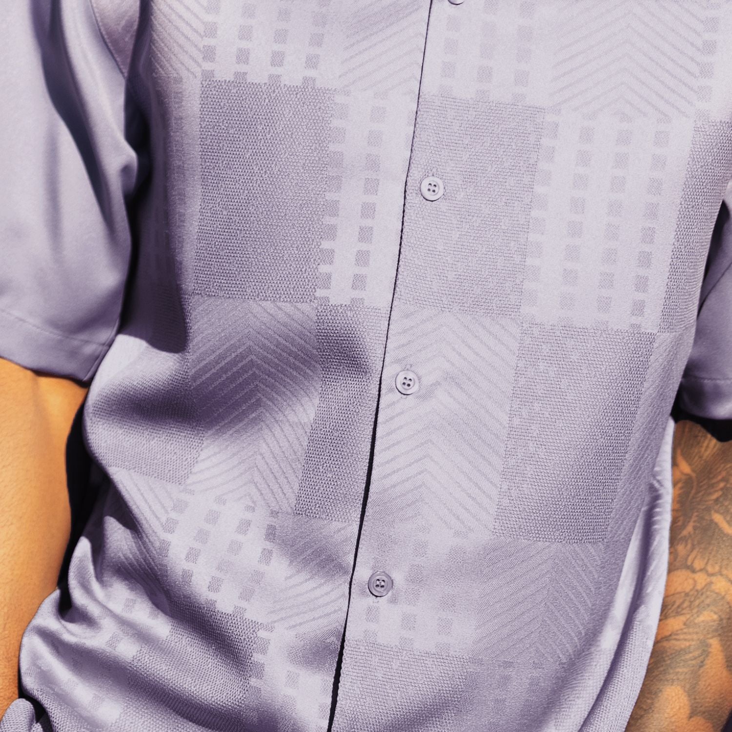 Close-up of the lilac shirt showing the detailed tonal jacquard panel weave and textured pattern.