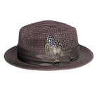 Brown Montique fedora hat side view with open weave crown, feather accent, satin ribbon band, and Montique logo pin