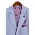 Close-up detail of light blue textured weave blazer fabric and lapel stitching