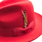Red wool felt fedora hat close-up with matching ribbon bow, feather accent, pinched crown, and soft felt texture