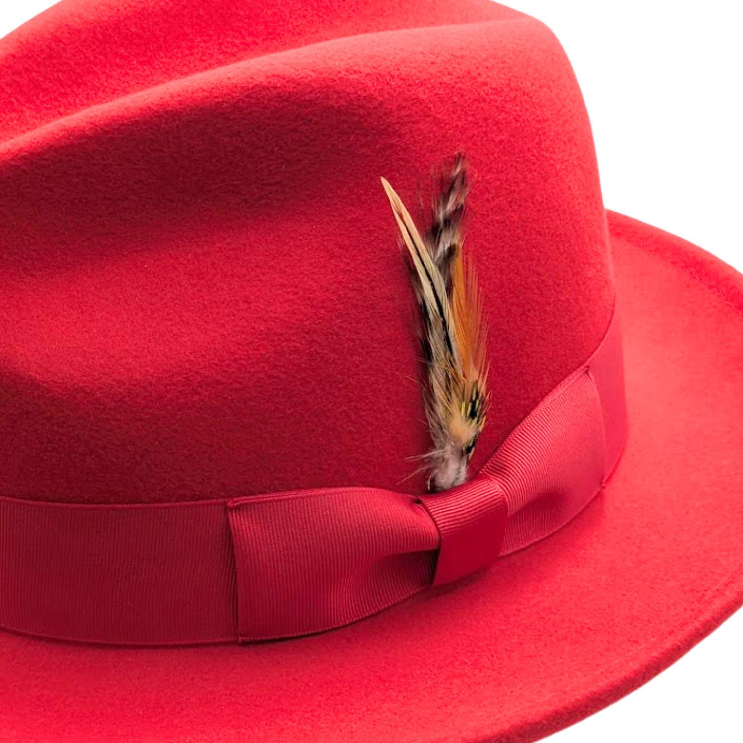 Red wool felt fedora hat close-up with matching ribbon bow, feather accent, pinched crown, and soft felt texture