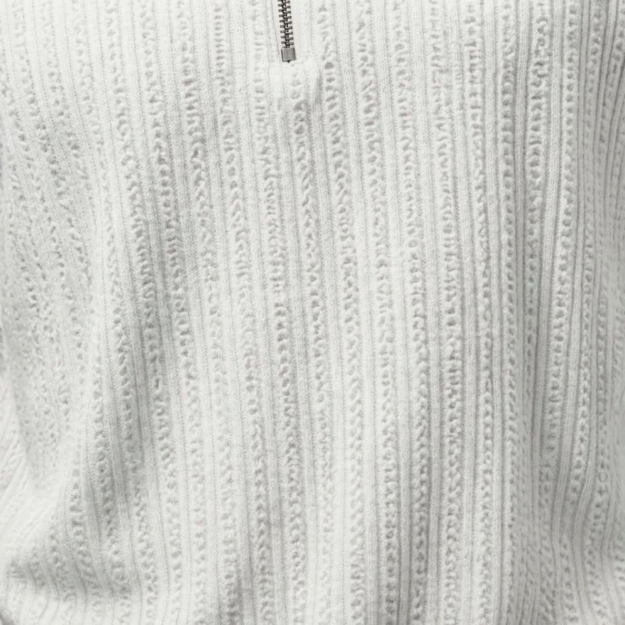 close-up of the white studded knit polo 