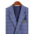Close-up of the blue windowpane plaid jacket on a hanger, showing notch lapels, chest pocket and lining.