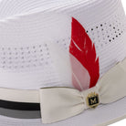 Close-up of white mesh fedora showing the striped satin ribbon and signature Montique crest pin.
