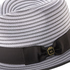 Close-up of the grey striped fabric texture and the signature Montique metal pin on the ribbon band.