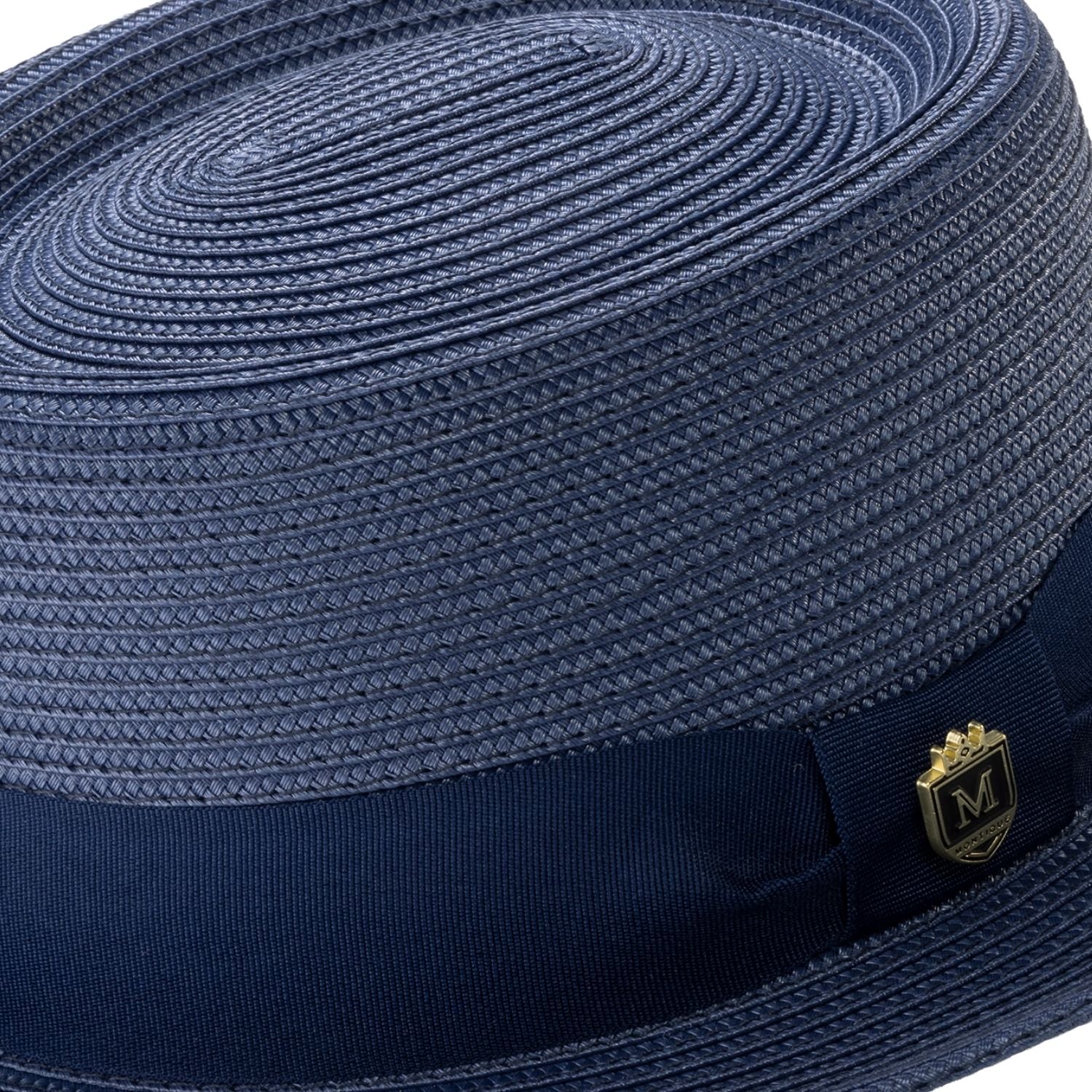 Close-up navy hat band and crest pin.