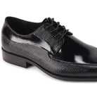 Close-up of black embossed leather texture and moc toe stitching detail.