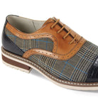 Close-up of tan leather brogue detail and navy blue patterned tweed texture