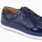 Close-up of cobalt blue embossed croc leather texture and smooth blue leather paneling.