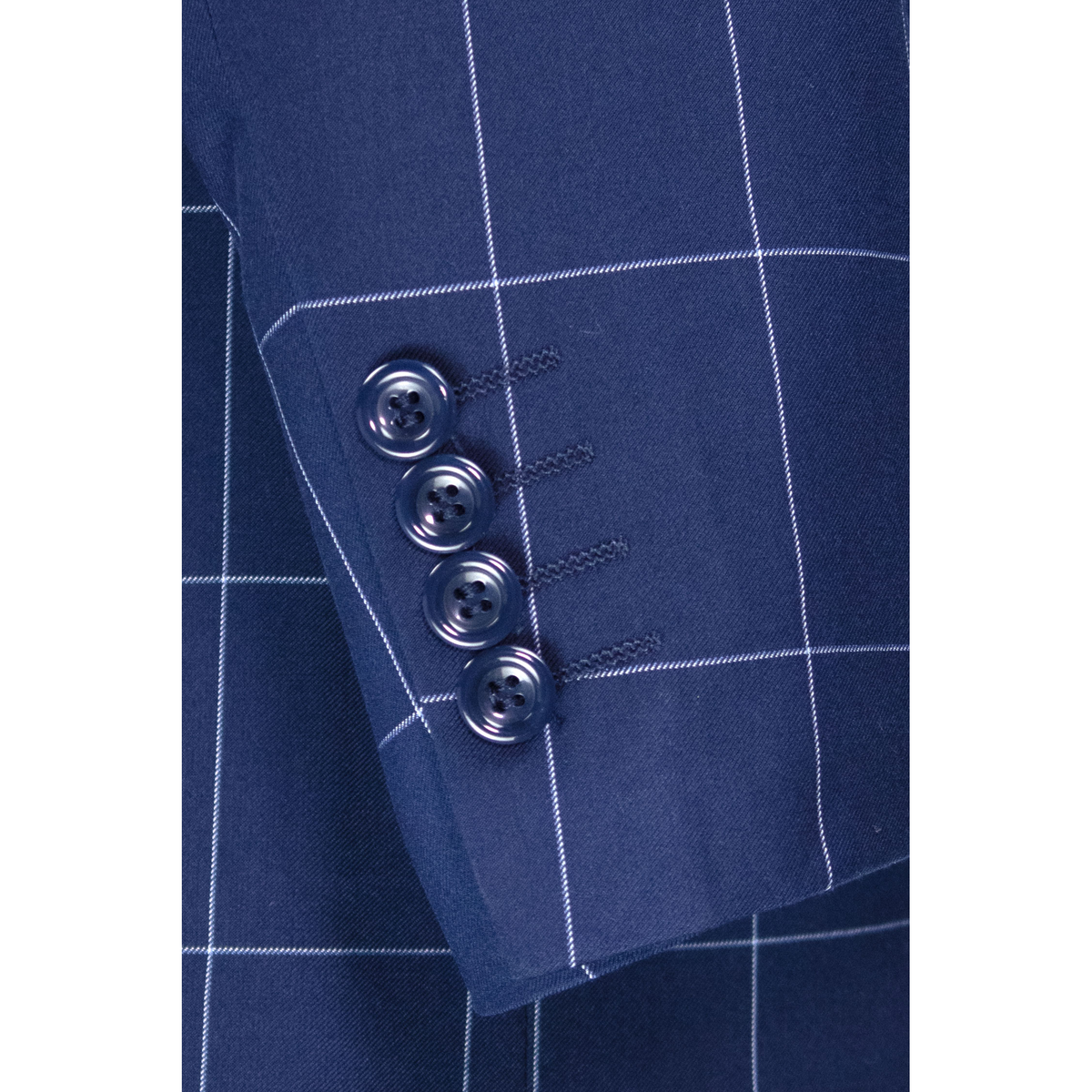 Close-up of the blue windowpane-check jacket sleeve, showing four blue cuff buttons and pale grid lines.