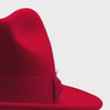 video of Red wool felt fedora hat close-up with matching ribbon bow, feather accent, pinched crown, and soft felt texture