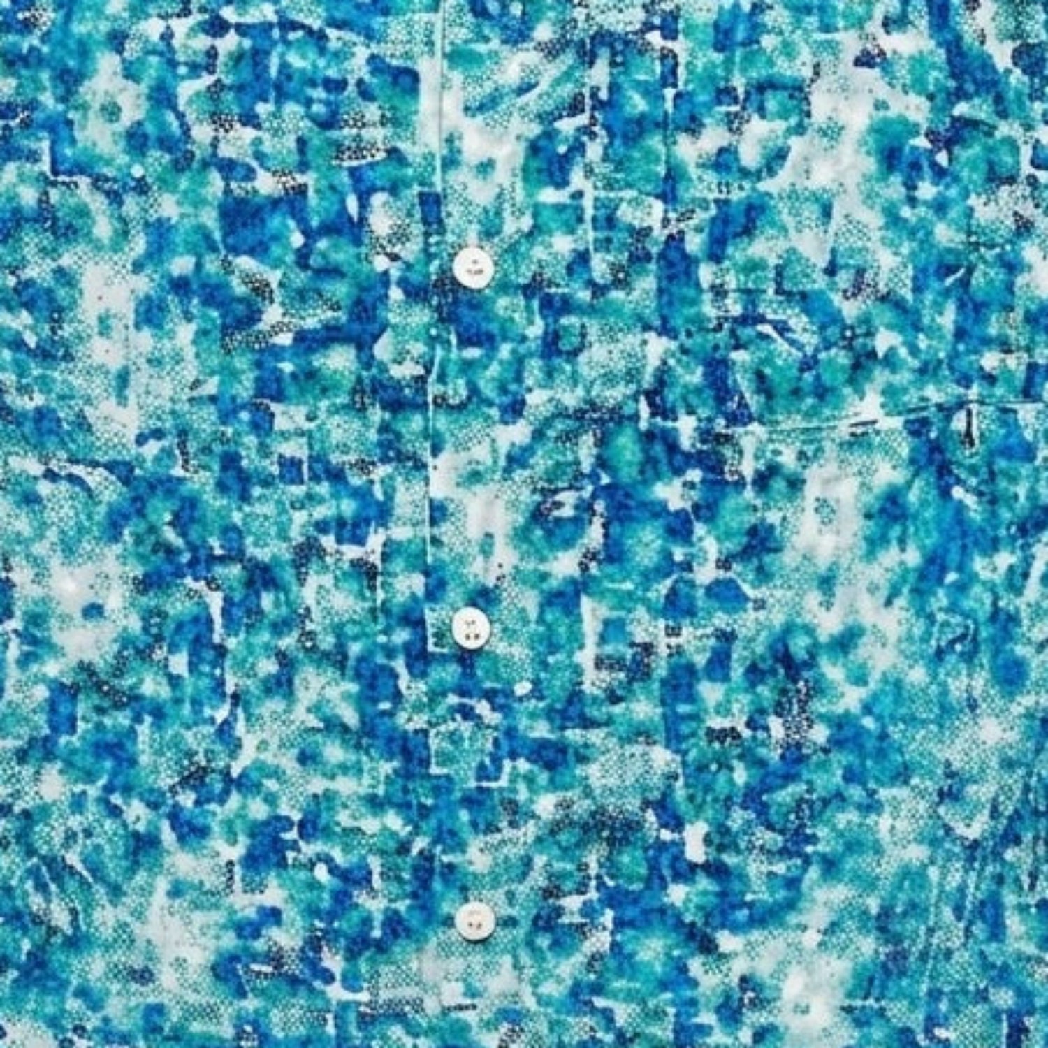 Close-up of the teal Silversilk shirt showing the abstract print and textured linen blend fabric.