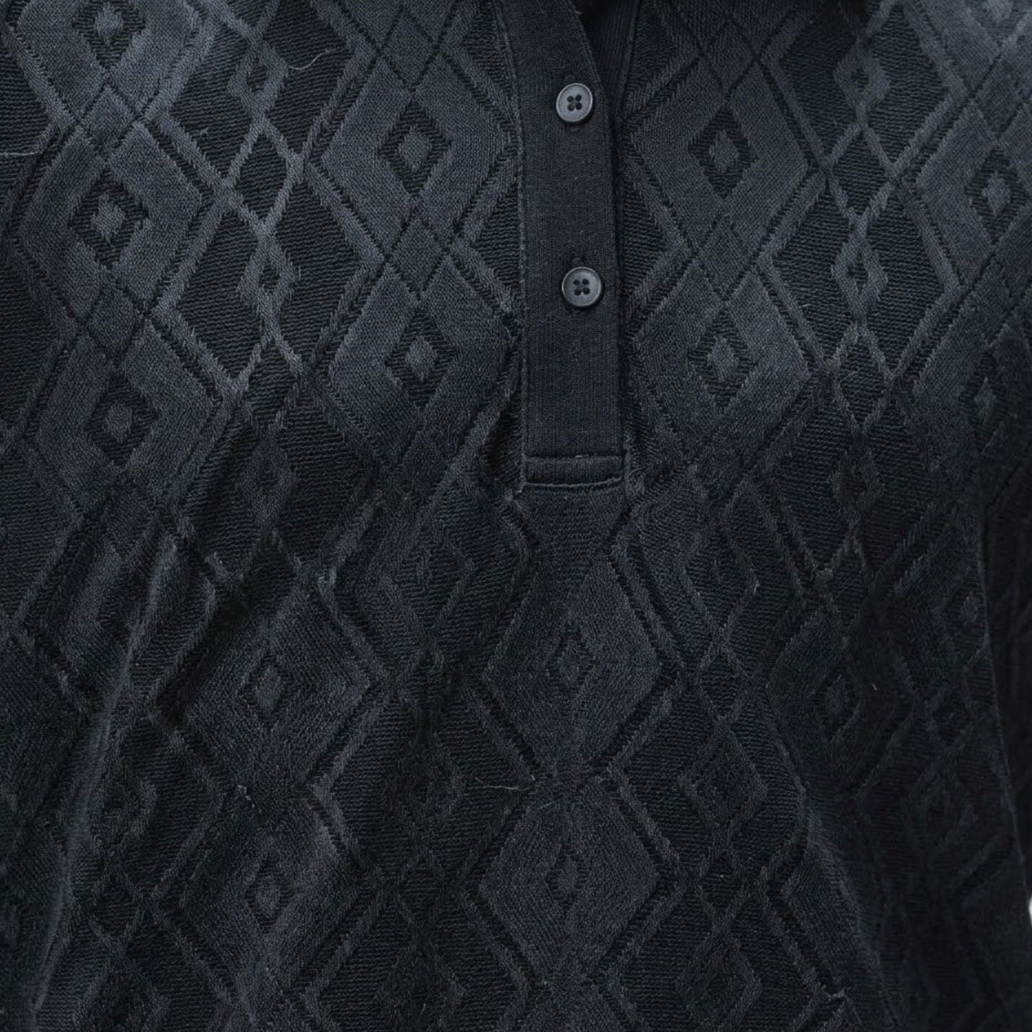 Close-up of the black textured knit fabric on a Stacy Adams polo highlighting the diamond motif and buttons.