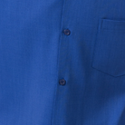 Close-up of cobalt 100% polyester fabric showing the solid texture and button detail